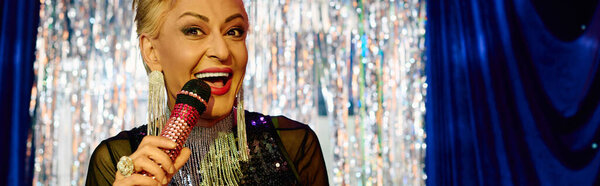 A drag performer shines with extravagant makeup and charisma during a lively holiday event.