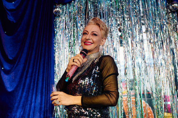 Королева трансвеститов очаровывает зрителей ярким макияжем и ослепительной одеждой на празднике.