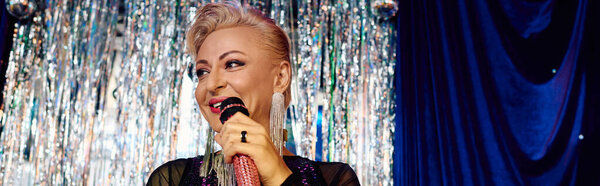 Ослепительная трансвестит с ярким макияжем на праздничном шоу.