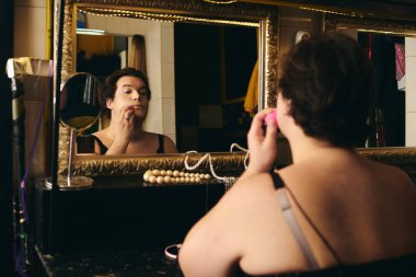 Canlı bir soyunma odasında, bir travesti tatil şovu için çarpıcı bir görünüm yaratmaya odaklanır..