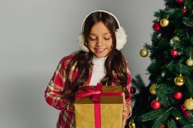 Samimi giyinen heyecanlı kız özel bir Noel anının tadını çıkarıyor hediye ve ağaçla.
