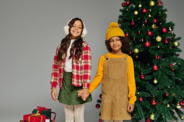 İki neşeli çocuk Noel 'i canlı hediyeler ve süslemelerle kutluyor..