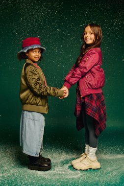 2025 'te Noel' in neşesini kucaklayan iki küçük kız el ele tutuşup birlikte gülümsüyorlar..