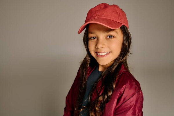 Bright smile of a young girl in a red cap, radiating happiness during Christmas festivities.