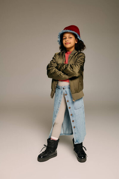 Young girl confidently showcases festive style in a cozy setting, symbolizing Christmas cheer.