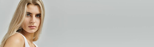 Светловолосая красота изящно позирует, демонстрируя современную моду с непринужденной, но шикарной атмосферой.