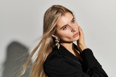 Göz kamaştırıcı genç bir kadın şık bir siyah elbisede güzellik ve moda uzmanlığını sergiliyor..