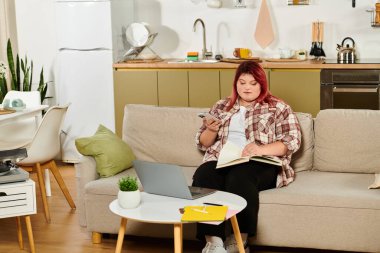 Büyük beden bir kadın, elinde not defteri ve telefonuyla şık bir koltukta oturur ve yaratıcılığı kucaklar..