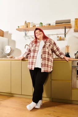 Şık bir mutfakta genç bir kadın rahatlık ve tarz içinde dinlenirken güzelliğini kucaklıyor..