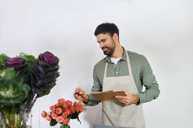 Yetenekli bir çiçekçi dükkanında müşterilerle meşgul olurken canlı çiçekler düzenler..