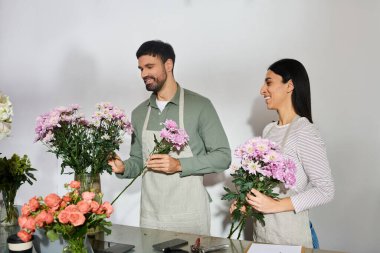 Karı koca neşe içinde dükkanlarında baş döndürücü çiçek buketleri yapıyorlar..