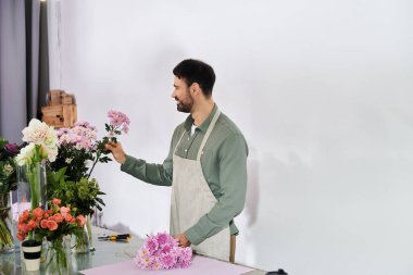 Yetenekli bir çiçekçi dükkanında göz kamaştırıcı düzenlemeler yapmak için canlı çiçekler seçer..