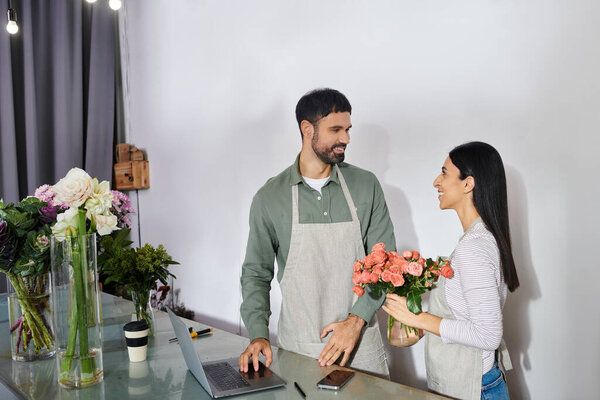A couple works together in their flower shop, arranging vibrant blooms with joy and passion.