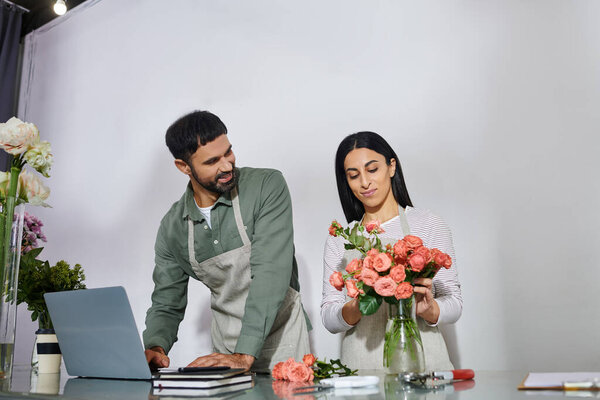 A husband and wife joyfully arrange flowers in their charming plant shop, creating beauty daily.