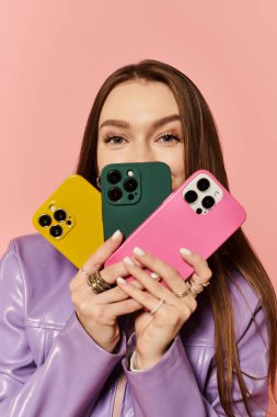 Güzel bir kadın canlı enerji ve tarzla gülümserken moda telefon kılıfları sergiliyor.