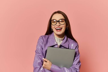 Vibrant woman showcases her stylish look while hugging a gray folder against a pink background. clipart