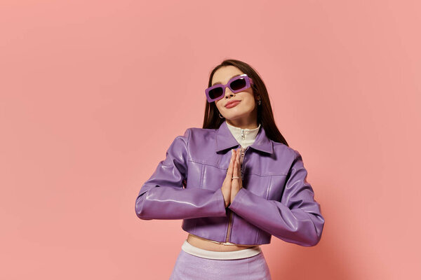 Стильная женщина уверенно стоит в молитвенной позе, выставляя напоказ свой модный наряд.