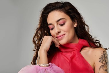 Canlı kıyafetler giyen güzel genç bir kadın poz verirken sakin bir ifade sergiliyor..