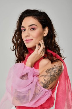 A young beautiful woman poses confidently, highlighting her artistic tattoos and colorful outfit. clipart