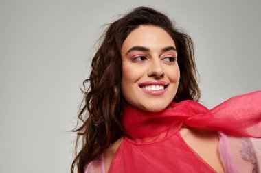 Uzun saçlı güzel genç bir kadın bu anın tadını çıkarıyor. Parlak gülüşünü içeride sergiliyor..