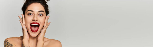 Молодая женщина с ярким макияжем радостно показывает волнение и счастье, позируя.