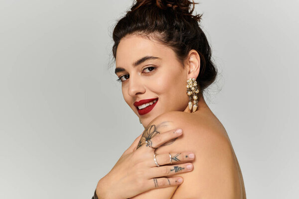 Молодая красивая женщина демонстрирует свою элегантность с смелыми серьгами и очаровательной улыбкой.