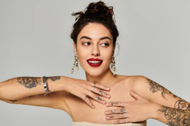 Genç ve güzel bir kadın zarif bir şekilde poz verir ve zarif mücevher koleksiyonunu sergiler..