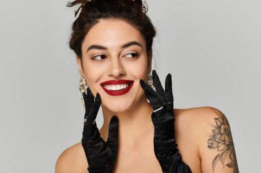 Parlak gülüşlü, zarif eldivenleri olan ve cazibesini gösteren kırmızı rujlu bir kadın..