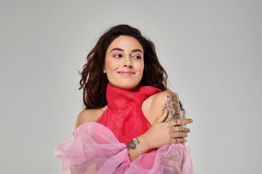 Kadın eşsiz tarzını kucaklarken gülümsüyor, güzelliğini ve özgüvenini gösteriyor..