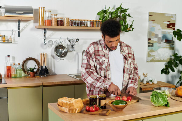 A young man skillfully chops vegetables while surrounded by kitchen ingredients.