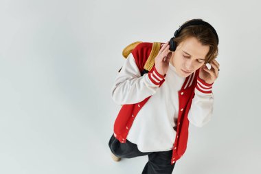 A handsome young man, dressed casually in a stylish bomber jacket, immerses himself in music. clipart