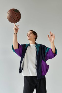 Genç bir adam basketbol yeteneklerini şık bir stüdyoda sergileyerek, kıyafetine yetenek katıyor..