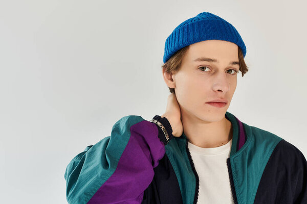 Young man showcases his fashionable bomber jacket while posing in a bright studio environment.