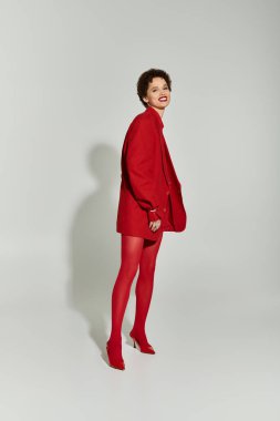 Genç ve güzel bir kadın, kendine olan güvenini cesur kırmızı elbisesine yansıtıyor, neşe ve tarz saçıyor..