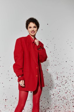 Genç bir kadın kendine güvenerek eşsiz moda anlayışını oyuncu bir arka plana karşı sergiliyor..