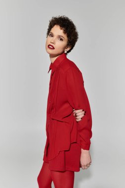 Bu güzel genç kadın cesur bir kırmızı elbise sergiliyor, kendine güveni ve tarzı var..