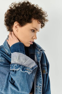 Kıvırcık saçlı, kendine güvenen genç bir kadın zarif moda anlayışını sergiliyor..