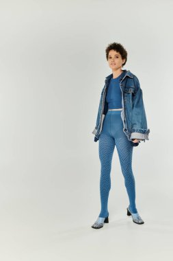 Genç ve güzel bir kadın zarif mavi elbiseler içinde zarifçe poz verir, zarafet ve cazibe saçar..