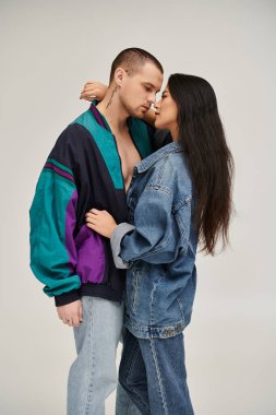 Şık giyinmiş genç bir çift stüdyoda sevgi dolu bir anı paylaşıyor..