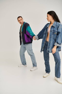 Moda kıyafetleri içinde genç ve güzel bir çift birlikte vakit geçirmekten zevk alıyor..