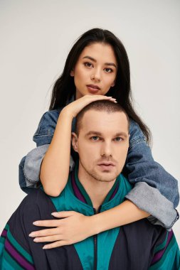 Güzel, genç bir çift şık kıyafetler içinde, sevgi ve bağlılık saçarak poz veriyor..