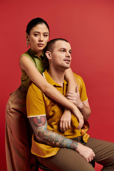 Молодая пара, одетая модно, выражает свою любовь на ярком фоне в студии.