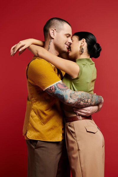 Красивая молодая пара обнимает тепло, излучая любовь и стиль в студии.