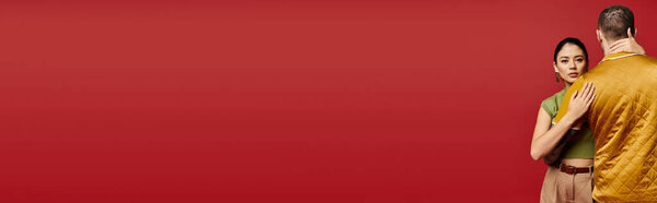 Молодая пара, одетая модно, обнимается в романтической студии, празднуя свою любовь, баннер