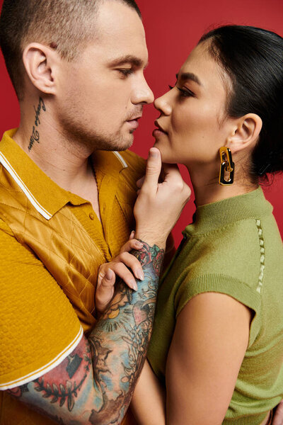 Красивая молодая пара в стильной одежде смотрит друг другу в глаза, празднуя любовь.