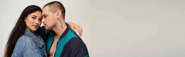 Очаровательная молодая пара демонстрирует свою любовь в студии, одетая в стильные наряды, баннеры