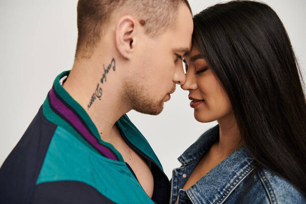 Красивая молодая пара разделяет интимный момент, одетый в модную одежду, празднуя любовь.