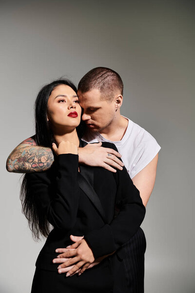 Красивая молодая пара обнимается в модной студии, демонстрируя свою любовь и моду.