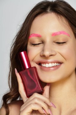 Genç kadın eşsiz güzelliğini pembe kaşlarıyla ve stüdyoda canlı bir ifadeyle vurguluyor..