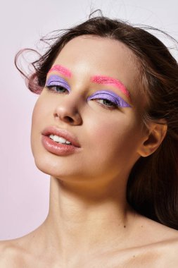 Güzellik ve yaratıcılık, genç bir kadının çarpıcı makyajını gri bir arkaplanda sergilemesiyle harmanlanır..